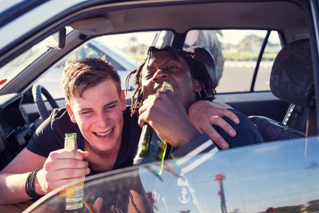 young adults partying and drinking alcohol in a car